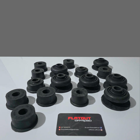 A set of black Toyota Hilux 1983 to 1998 rubber bushings arranged on a white surface with a gray background, alongside a black card labeled 'FLATOUT OFFROAD'.